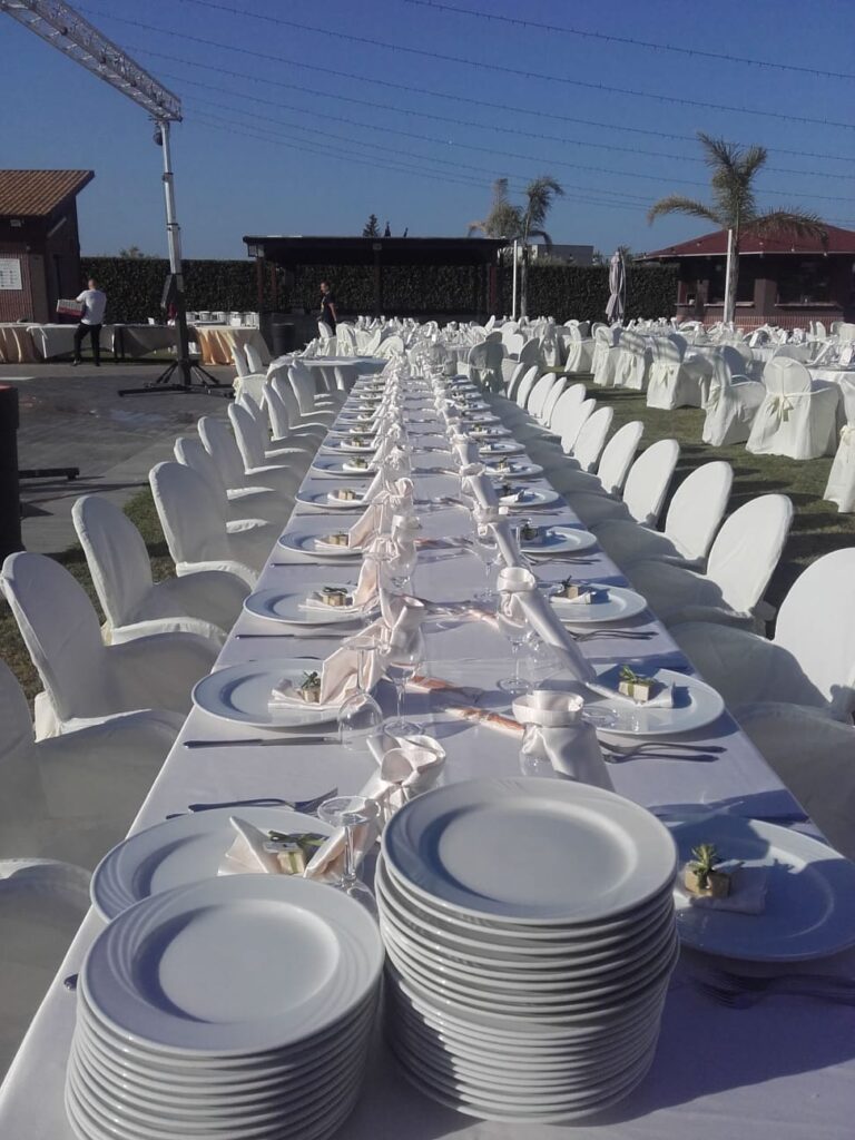 Catering Savini con lungo tavolo elegantemente apparecchiato, tovaglie bianche, decorazioni floreali e mise en place curata per un evento speciale