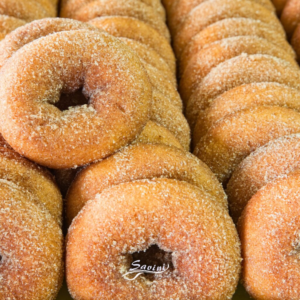 Ciambelle fritte ricoperte di zucchero, dolci tipici serviti freschi al Savini Bar.