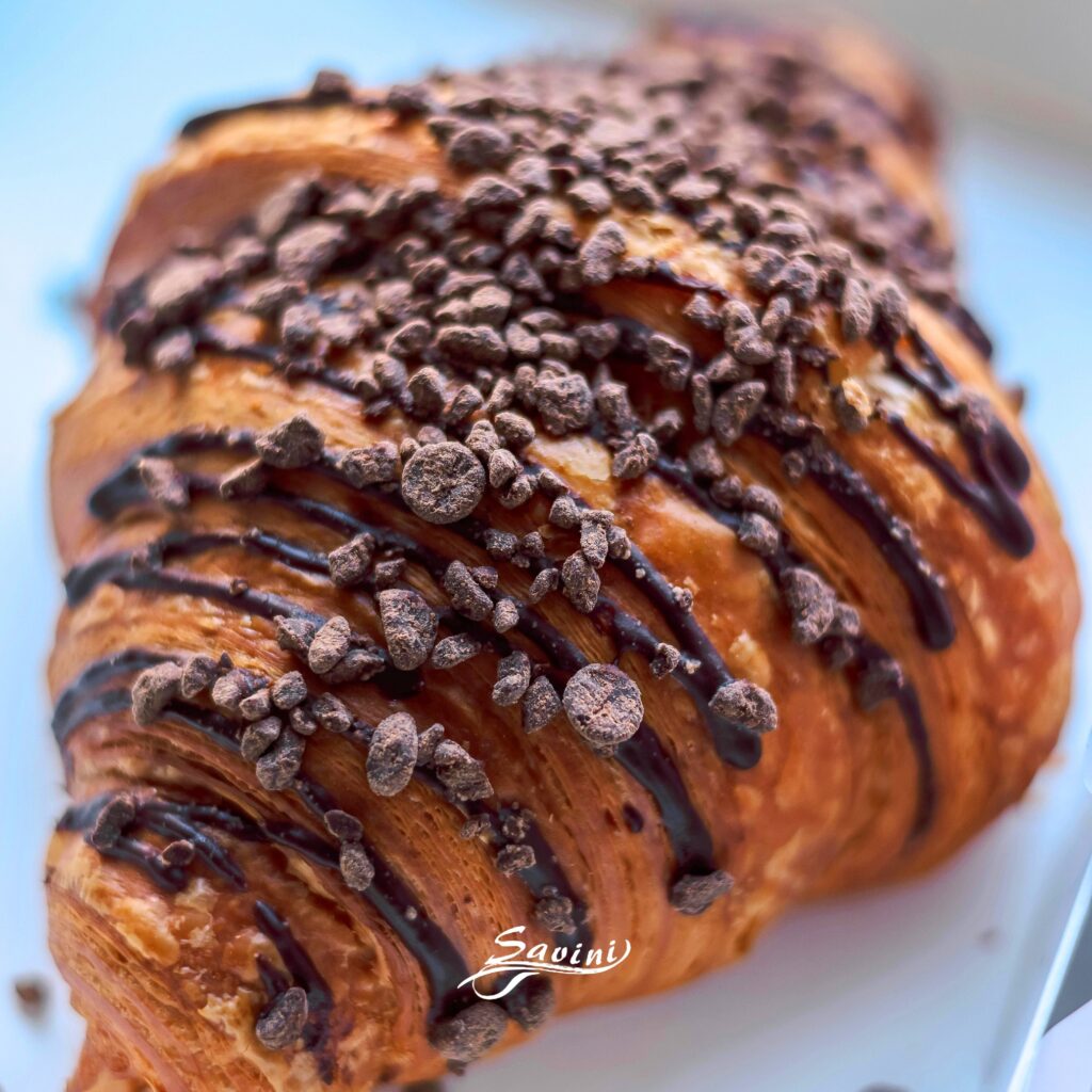 Cornetto artigianale al cioccolato con granella fondente, colazione del Savini Bar.