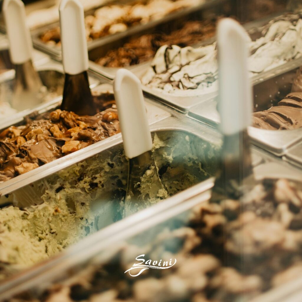 Vaschette di gelato artigianale assortito con palette da servizio in primo piano