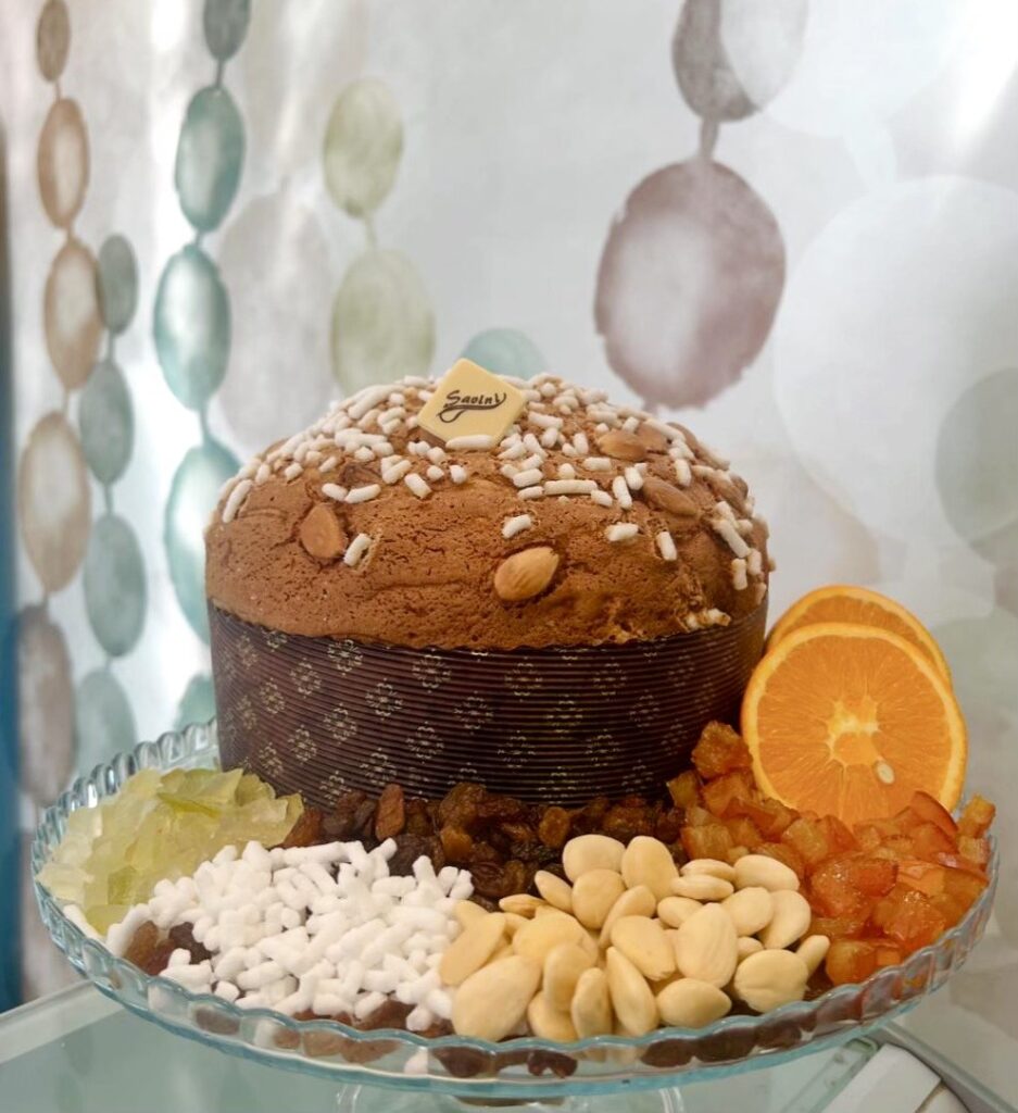 Panettone artigianale Savini con croccante copertura alle mandorle e glassa dorata, realizzato con ingredienti genuini e lievitazione naturale.